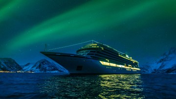 A cruise ship sailing under the Northern Lights